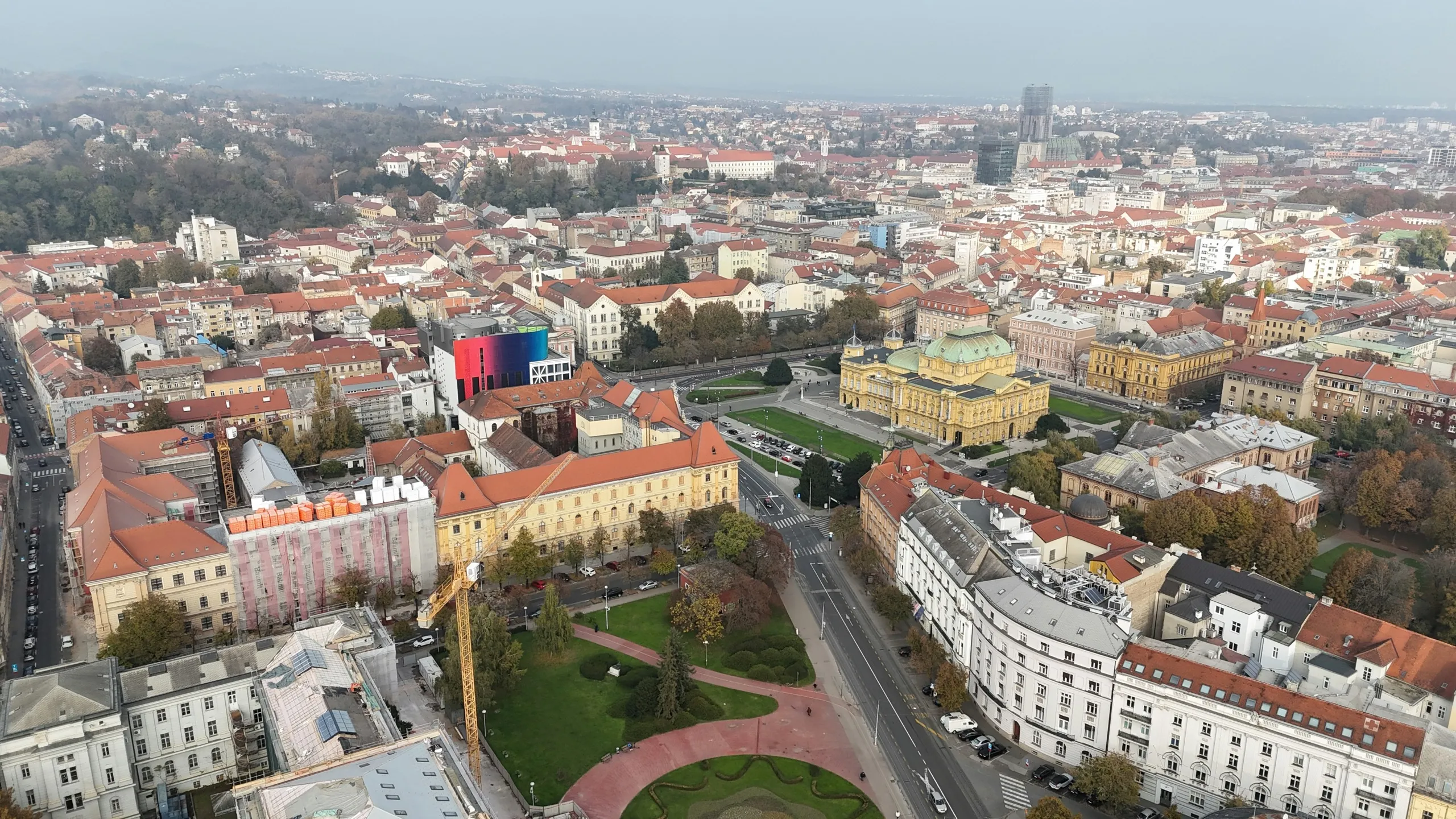 Central Zagreb under flat autumn light: old town rooftops, the Croatian National Theatre and the cathedral spires on the horizon