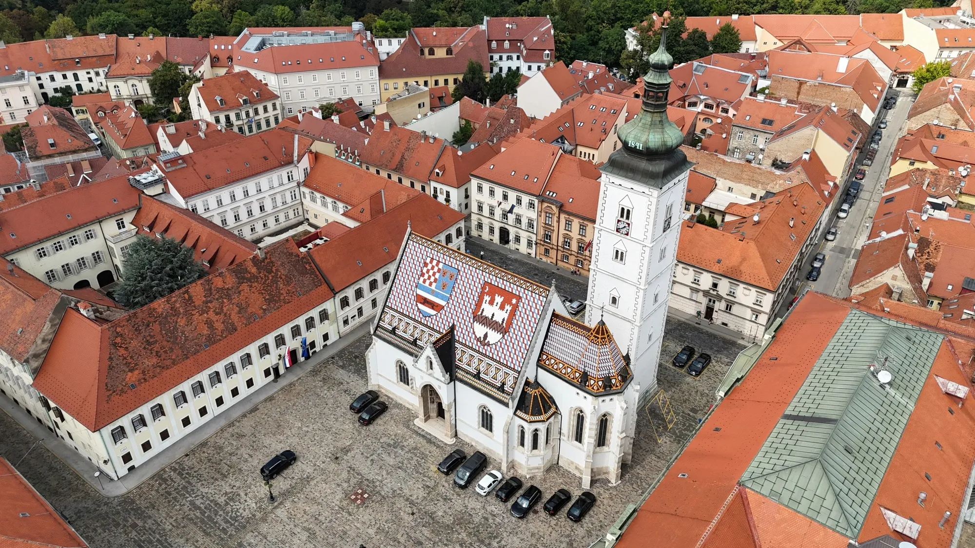Aerial view of St. Mark's Church in Zagreb with its coloured tile roof, surrounded by the red rooftops of the Upper Town